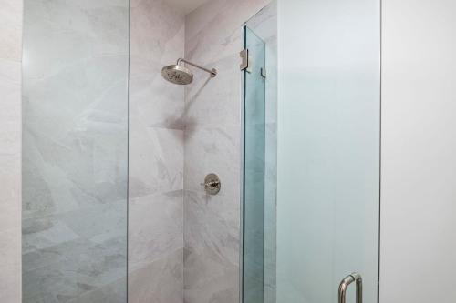a shower with a glass door in a bathroom at Casa Jardin - Boutique Suites in Downtown Santa Barbara in Santa Barbara
