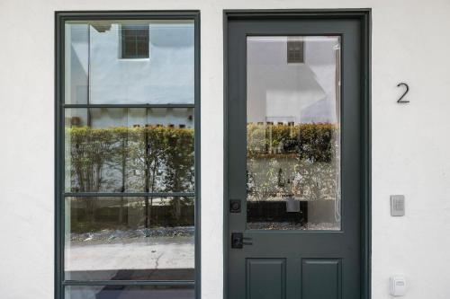 a door to a building with two windows at Casa Jardin - Boutique Suites in Downtown Santa Barbara in Santa Barbara
