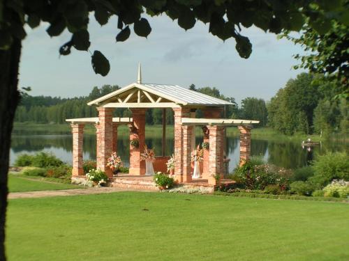 a gazebo in a park next to a lake at Birinu Pils in Bīriņi