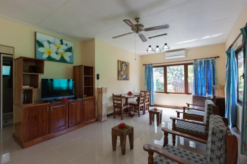 a living room with a television and a table at Le Relax Self Catering Apartment in La Digue