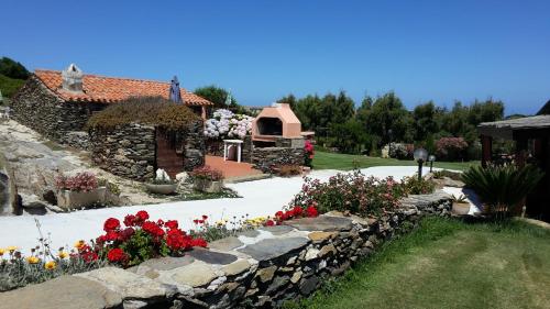 a garden with flowers and a stone wall at La Chintana in Palmadula