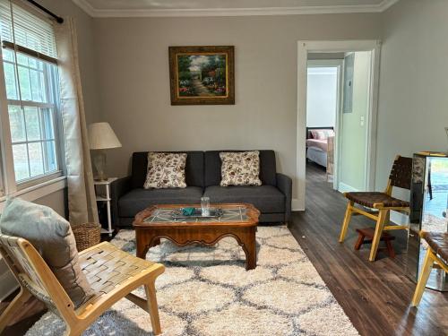 a living room with a couch and a coffee table at Pine Haven Getaway -Crib, Pets Welcome, Perfect for Families & Groups in Birmingham