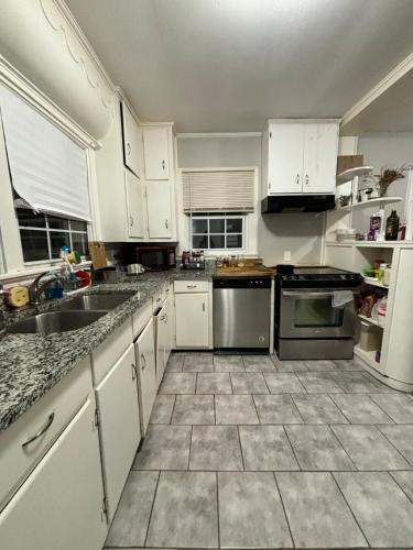 a kitchen with white cabinets and stainless steel appliances at Pine Haven Getaway -Crib, Pets Welcome, Perfect for Families & Groups in Birmingham