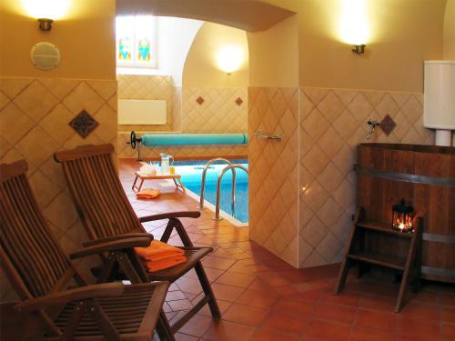 a room with two chairs and a swimming pool at Birinu Pils in Bīriņi