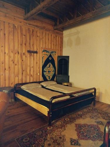 a bedroom with a bed in a room with wooden walls at Gypsy Camp Apartments & Glamping in Liepāja