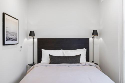 a bedroom with a large white bed with two lamps at Casa Jardin - Boutique Suites in Downtown Santa Barbara in Santa Barbara