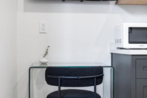 a chair sitting at a table with a microwave at Casa Jardin - Boutique Suites in Downtown Santa Barbara in Santa Barbara