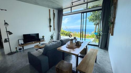 a living room with a couch and a table at Pahili Pool Villas Koh Tao - SHA Plus in Koh Tao