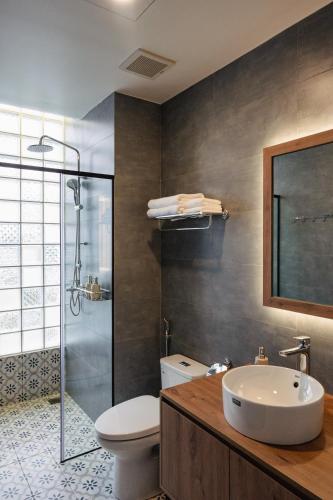a bathroom with a sink and a toilet and a shower at Ấm Boutique Hotel in Ấp Ða Lợi