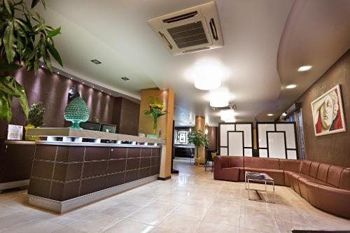 a lobby with couches and a bar in a hospital at Melqart Hotel in Sciacca