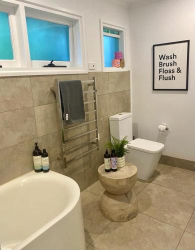 a bathroom with a bath tub and a toilet at Mt Martha - Mar Vista - Panorama views with Modern coastal style in Mount Martha
