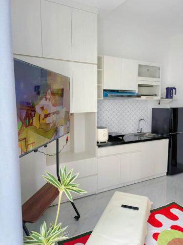 a kitchen with white cabinets and a table with a plant at Corgi House Central Nha Trang in Nha Trang