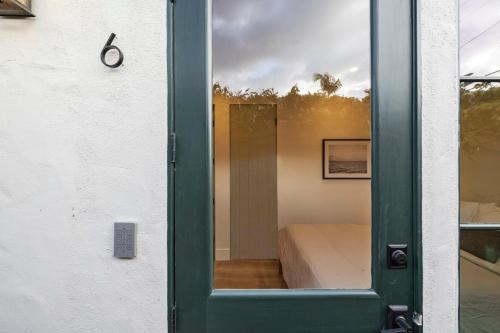 a glass door with a bed in a room at Casa Jardin - Boutique Suites in Downtown Santa Barbara in Santa Barbara