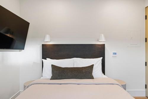 a bedroom with a large bed with a brown headboard at Casa Jardin - Boutique Suites in Downtown Santa Barbara in Santa Barbara
