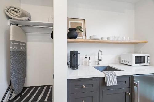 a kitchen with a sink and a microwave at Casa Jardin - Boutique Suites in Downtown Santa Barbara in Santa Barbara