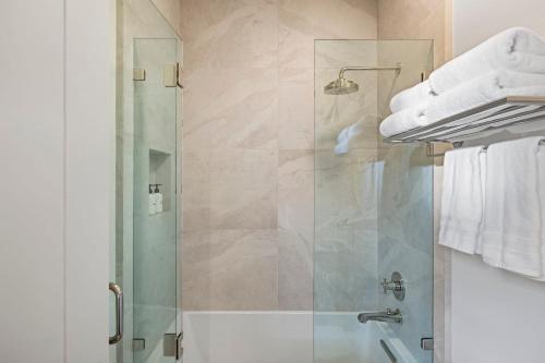 a bathroom with a shower with a glass door at Casa Jardin - Boutique Suites in Downtown Santa Barbara in Santa Barbara