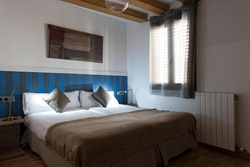 1 dormitorio con 1 cama grande, paredes azules y ventana en MH Apartments Liceo, en Barcelona