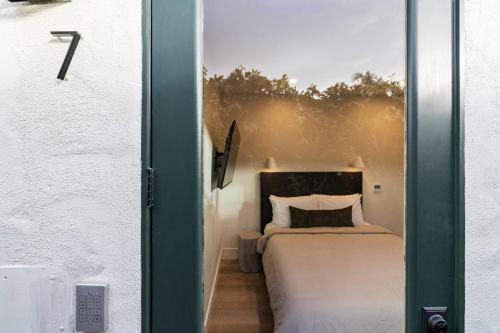 a bedroom with a bed through a glass door at Casa Jardin - Boutique Suites in Downtown Santa Barbara in Santa Barbara