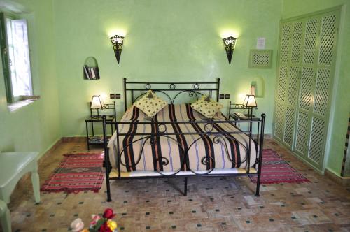 a bedroom with a bed and two lamps and two tables at Hotel Dar Zitoune Taroudant in Taroudant