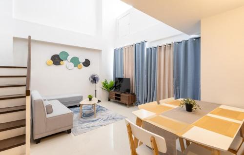 a dining room and living room with a table and chairs at Cozy & Homey 3-Bedroom in Iloilo City