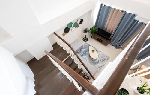 a staircase with a couch and a tv in a room at Cozy & Homey 3-Bedroom in Iloilo City