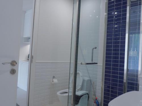 a bathroom with a toilet and a glass shower at Sunset town Phú Quốc in Phu Quoc