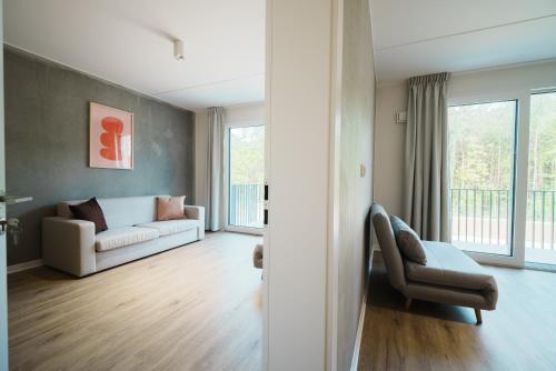 a living room with a couch and a chair at NA WYDMIE Apartments&Camp in Dziwnówek