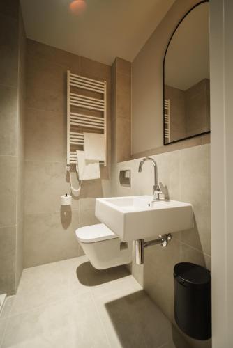 a bathroom with a sink and a toilet at NA WYDMIE Apartments&Camp in Dziwnówek