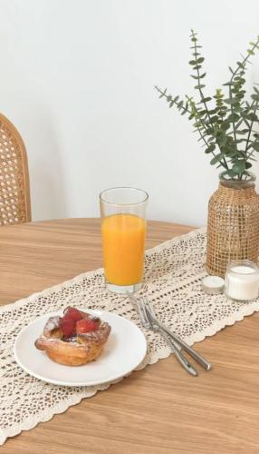 a plate of fruit on a table with a glass of orange juice at Sillim Queen House in Seoul
