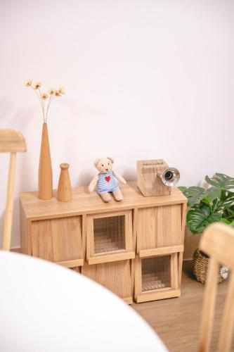 a teddy bear sitting on a wooden table at Sillim Queen House in Seoul