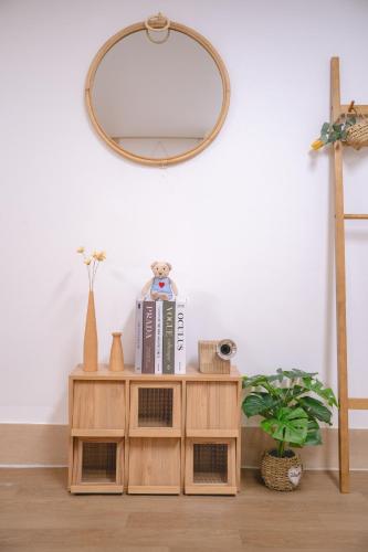 a mirror above a wooden shelf with books and books at Sillim Queen House in Seoul