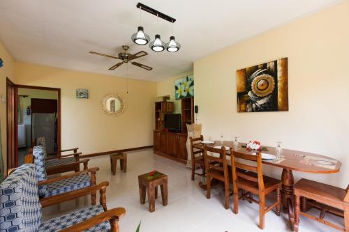 a living room with a dining room table and chairs at Le Relax Self Catering Apartment in La Digue