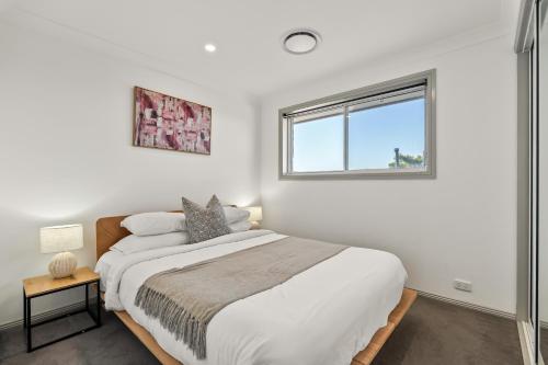 a bedroom with a large bed and a window at Diamond Head Manor - Pool, Water Views, Central in Budgewoi