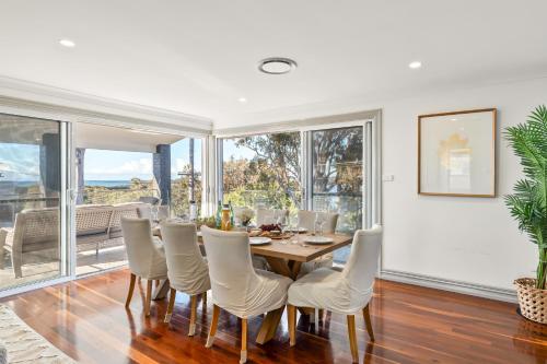 a dining room with a table and chairs at Diamond Head Manor - Pool, Water Views, Central in Budgewoi