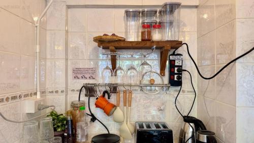 Una cocina con un estante con muchos frascos de vidrio. en Baan PadSeeEw - Rooftop Riverview 3rd floor, en Thonhuri