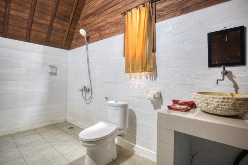 un baño con inodoro y lavabo en Megaland Bungalow, en Nusa Penida