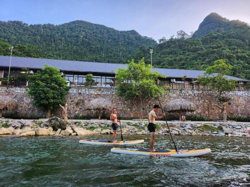 two men are on paddle boards in the water at Jasmine Retreat 