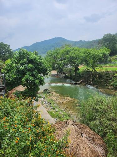 a river with trees and a field with at Jasmine Retreat 