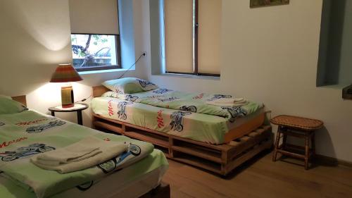 two twin beds in a room with a window at Guest House Art Eco Land in Ganchovets