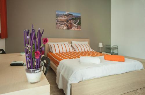 a bedroom with two beds and a table with flowers at Ragusa Terra Priziusa in Ragusa