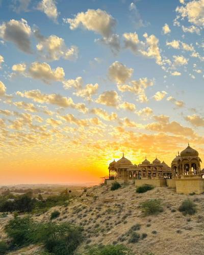 a building on top of a hill with a sunset at Hotel Royal Heritage in Jaisalmer