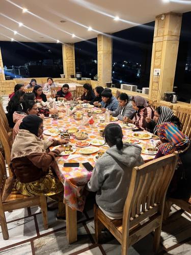 a group of people sitting at a table eating food at Hotel Royal Heritage in Jaisalmer