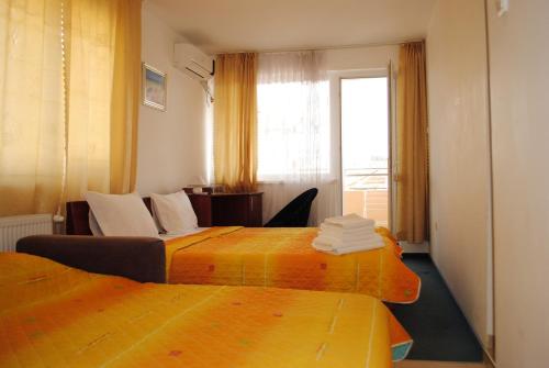a hotel room with two beds and a window at Veda Guest House in Pomorie
