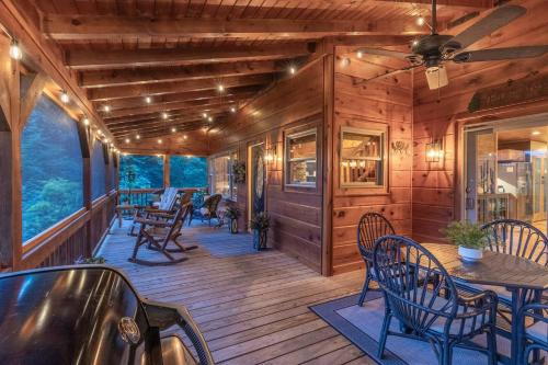 a wooden deck with tables and chairs on it at Fall25 Offhottubviewsfirepitwcu3minfamilies in Sylva