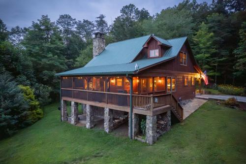 a large wooden house with a green roof at Fall25 Offhottubviewsfirepitwcu3minfamilies in Sylva