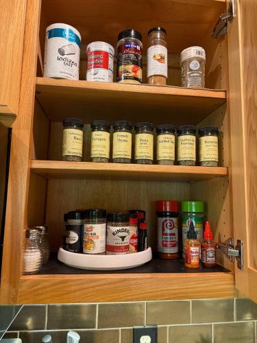 a cabinet filled with lots of jars of spices at Fall25 Offhottubviewsfirepitwcu3minfamilies in Sylva