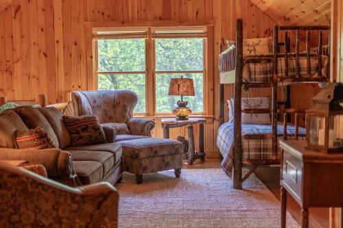 a living room with a couch and a bunk bed at Fall25 Offhottubviewsfirepitwcu3minfamilies in Sylva