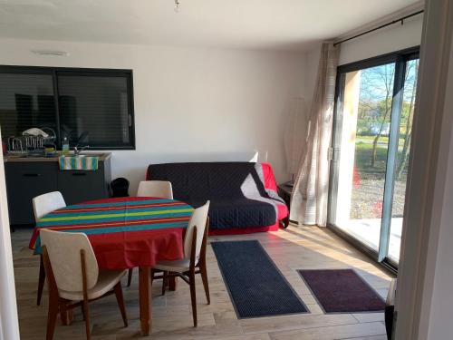un salon avec une table, des chaises et un canapé dans l'établissement La Caronnière, à Fort-Mahon-Plage