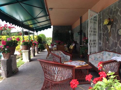 a patio with a table and chairs and flowers at Villa Nanda a 15 minuti da Roma piscina esclusiva , villa nella natura in Formello