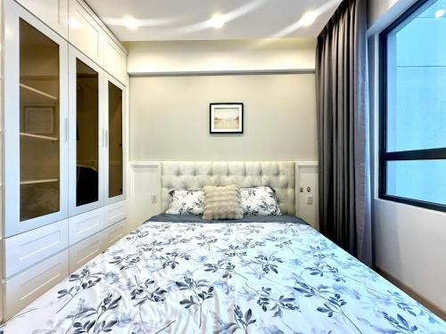 Un dormitorio con una cama con un edredón azul y blanco. en Masteri Thao Dien Apartment Complex, en Kon Rung (1)
